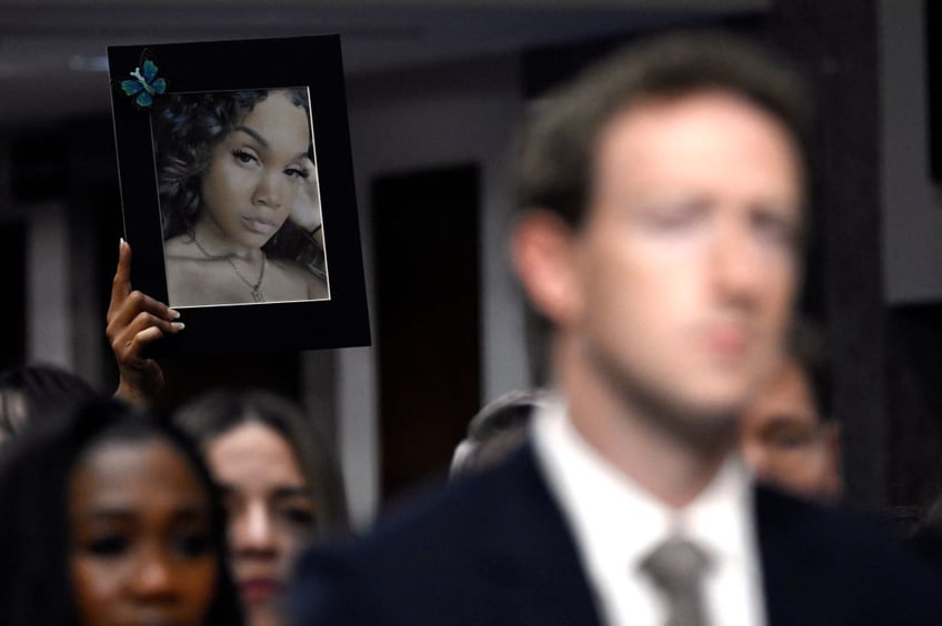 Mark Zuckerberg (R), CEO of Meta, arrives to testify before the US Senate Judiciary Committee hearing, "Big Tech and the Online Child Sexual Exploitation Crisis," as relatives hold portraits of victims, in Washington, DC, on January 31, 2024. (Photo by ANDREW CABALLERO-REYNOLDS / AFP) (Photo by ANDREW CABALLERO-REYNOLDS/AFP via Getty Images)