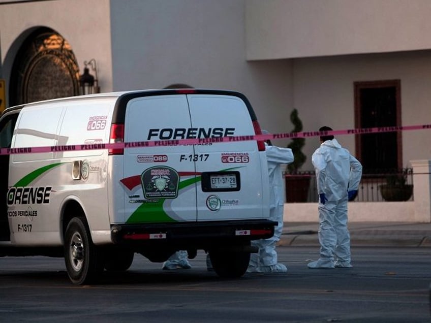 Mexican forensic personnel wait outside an exclusive restaurant in Ciudad Juarez, Chihuahu