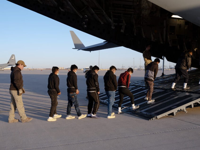 U.S. Customs and Border Protection security agents guide illegal aliens onboard a C-17 Glo