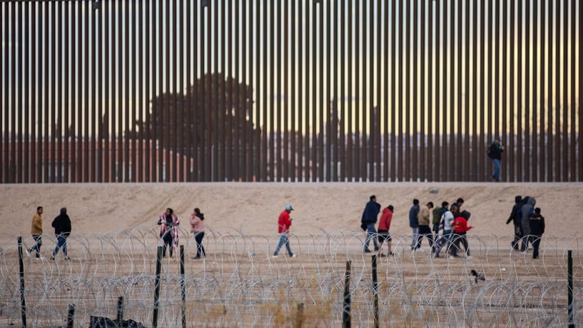 migrants at Texas border wall