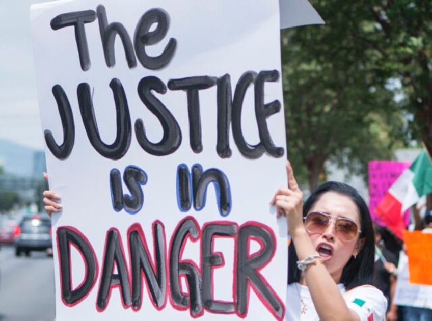 A Mexican judicial worker protests against controversial reforms proposed by outgoing Pres