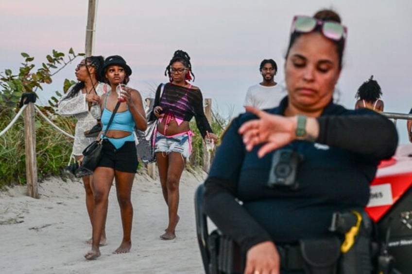 Tourists leave after Miami Beach police closed access on during the Spring Break weekend o