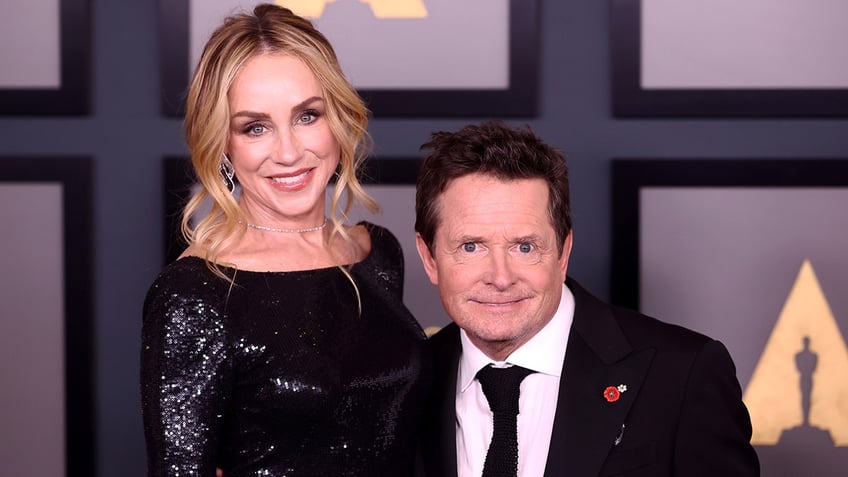 Michael J. Fox poses for a photo with wife Tracy on the red carpet at the Academy of Motion Picture Arts and Sciences - he is significantly shorter than her