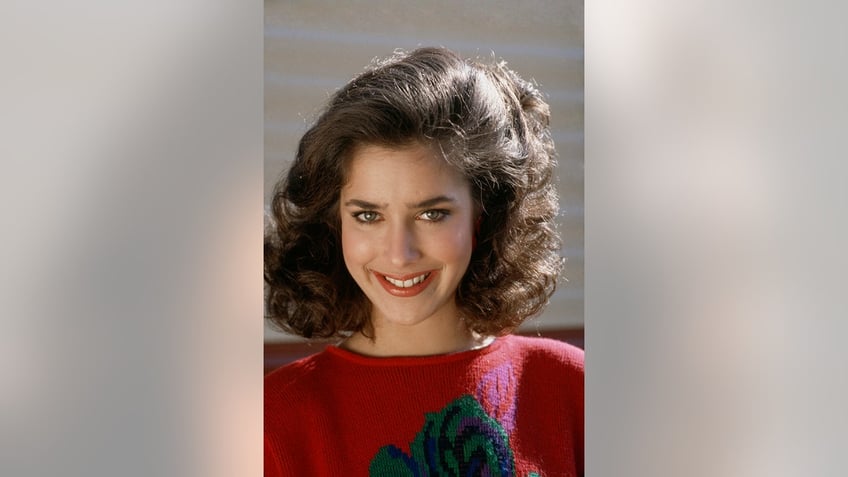 Claudia Wells wearing a red sweater.