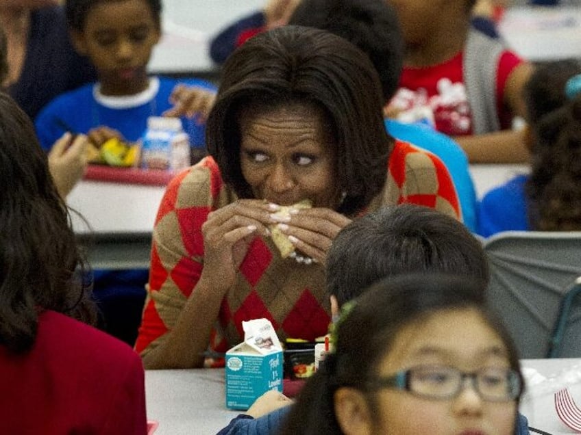 First lady Michelle Obama takes a bit of her turkey taco as she has lunch with school chil