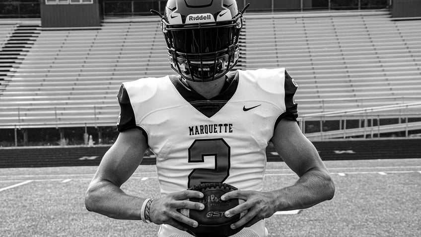 Jordan DeMay holding a football