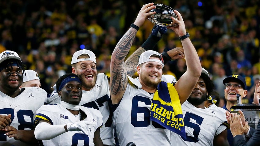 Zak Zinter raises the Big Ten trophy