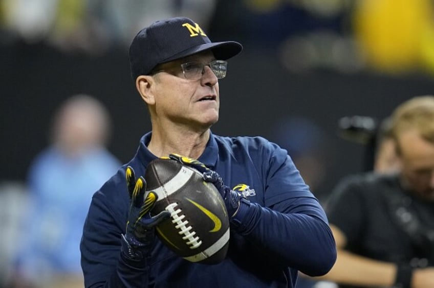 Michigan head coach Jim Harbaugh throws a football before the Big Ten championship NCAA college football game against Iowa, Saturday, Dec. 2, 2023, in Indianapolis. (AP Photo/Darron Cummings)