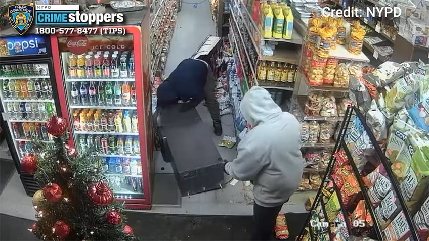 Two men drag an ATM out of a convenience store