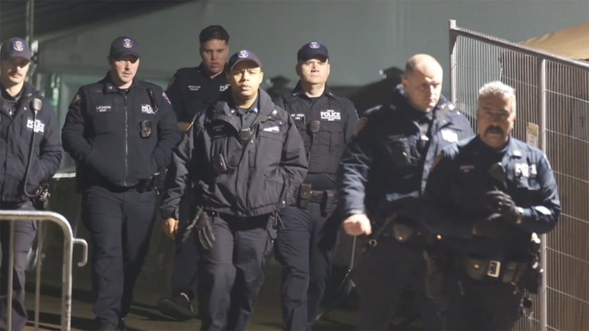 Police officers depart a migrant shelter on Randall's Island in New York