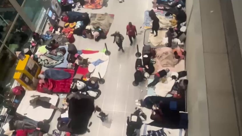 airport floor crowded with migrants sleeping