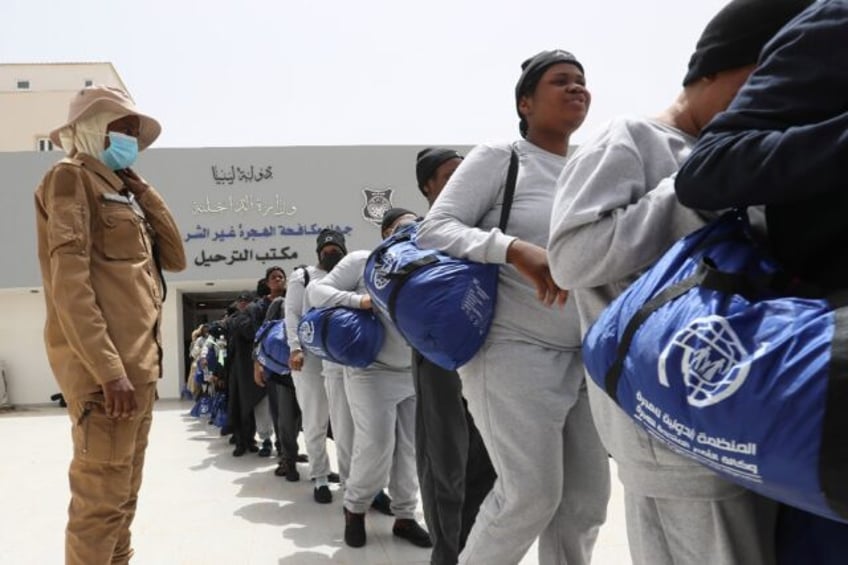 Nigerian migrants queue as they wait to be deported from Libya