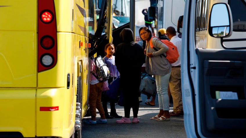 Venezuelan migrants board buss at Martha's Vineyard, Massachusetts.