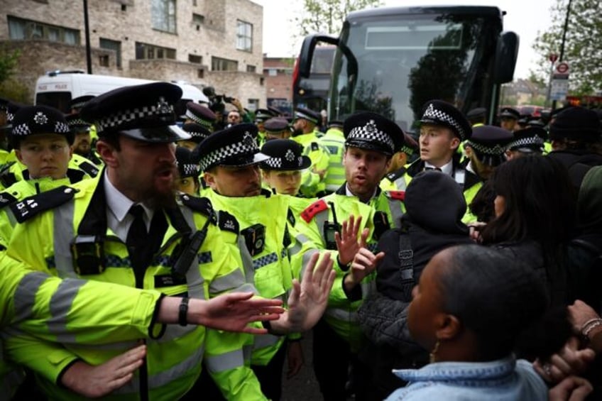 Metropolitan Police officers clash with protesters taking part in a gathering around a bus