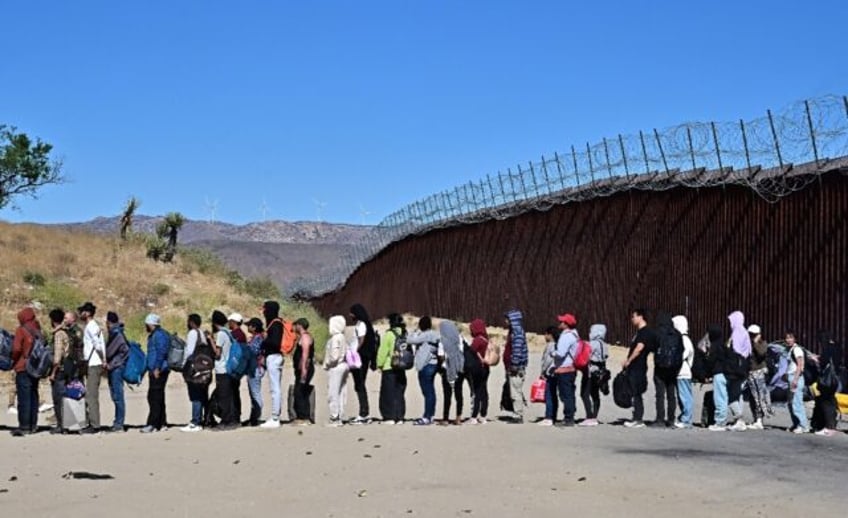 Migrants wait in line hoping for processing from Customs and Border Patrol agents at Jacum