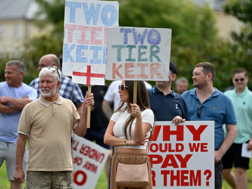 Protesters hold placards during a 'Enough is Enough' demonstration called by far-right act
