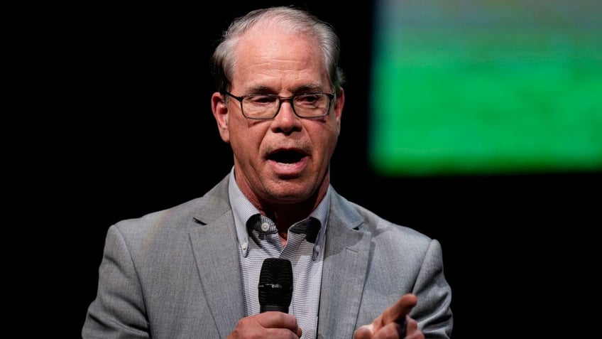 Sen. Mike Braun holding microphone, gesturing with left hand