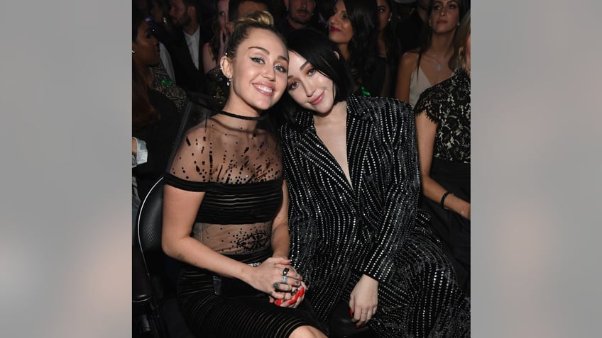 miley cyrus and her sister noah at the grammys in 2019