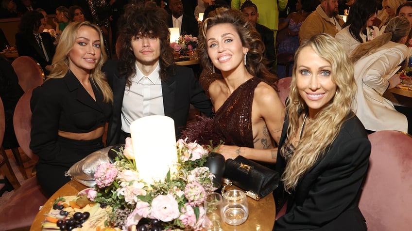 Miley Cyrus sits with her family and boyfriend at the Grammys