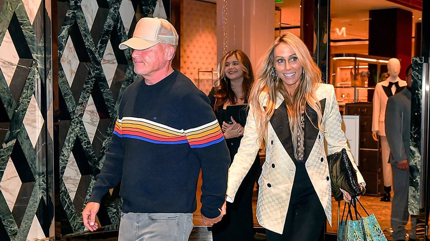 Dominic Purcell in a hat walking hand in hand with Tish Cyrus