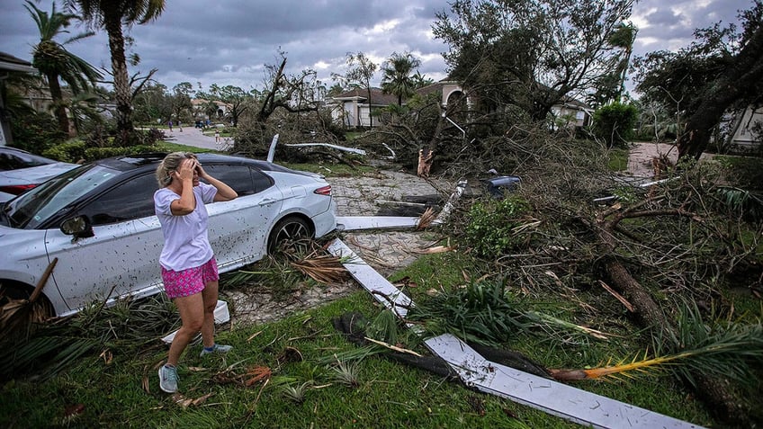 Marie Cook reacts to the damage to her home in the Binks Estates community after a tornado formed by Hurricane Milton touched down