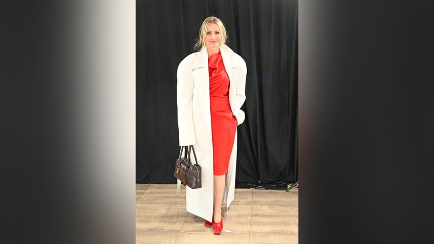 Cameron Diaz wore a red dress with a white coat to the Stella McCartney fashion show in Paris.