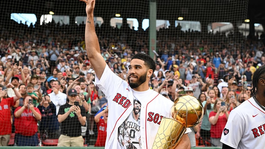 Jayson Tatum holds NBA trophy at Red Sox game