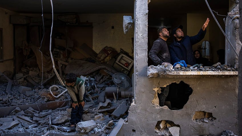 Palestinians look at airstrike damage