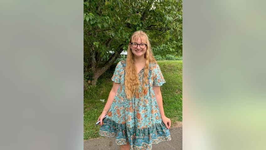 Jessica Barnes wearing a dress and black framed glasses