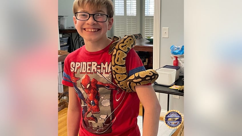 Sebastian Rogers pictured with a snake on his arm