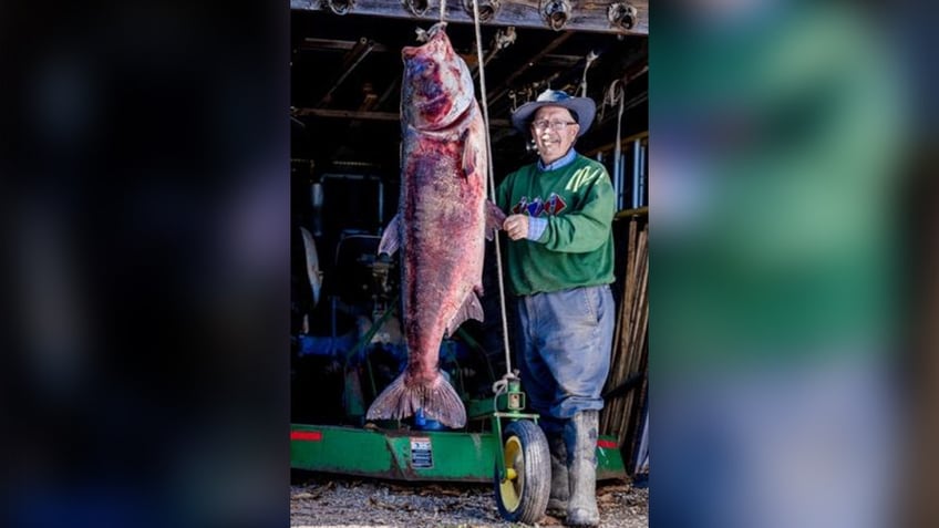 George Chance standing with bighead carp catch