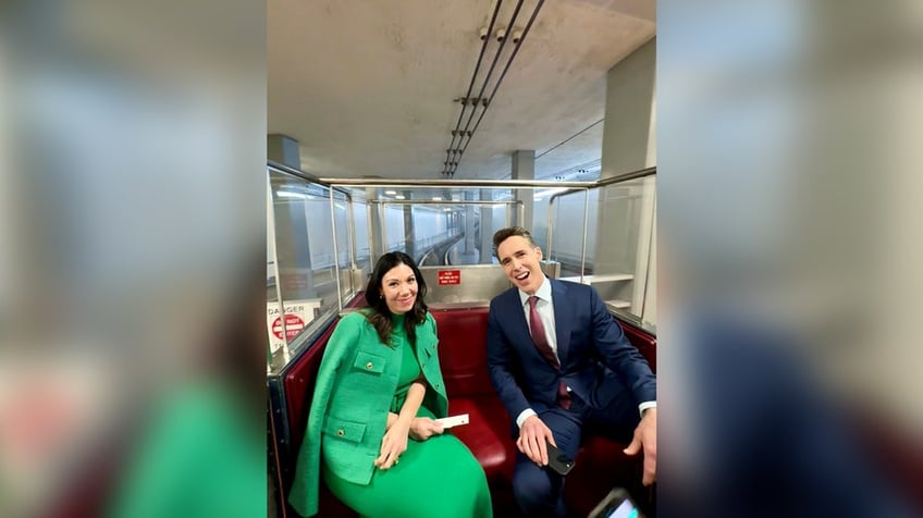 A woman in green poses with Sen. Josh Hawley