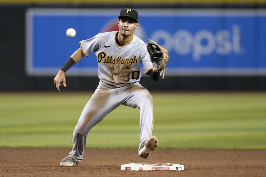 FILE - Pittsburgh Pirates shortstop Tucupita Marcano takes a throw down to second base during the fifth inning of a baseball game against the Arizona Diamondbacks, July 7, 2023, in Phoenix. Major League Baseball has permanently banned Marcano, Tuesday, June 4, 2024, for betting on baseball and suspended the four other players for one year after finding the players placed unrelated bets with a legal sportsbook. (AP Photo/Ross D. Franklin, File)