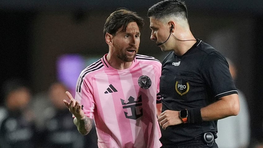 Lionel Messi talks to a ref