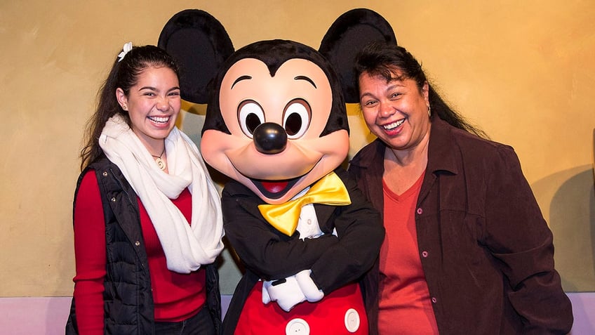 Cravalho and her mom with Mickey Mouse smiling