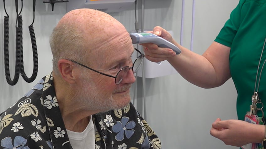 A man gets his temperature checked