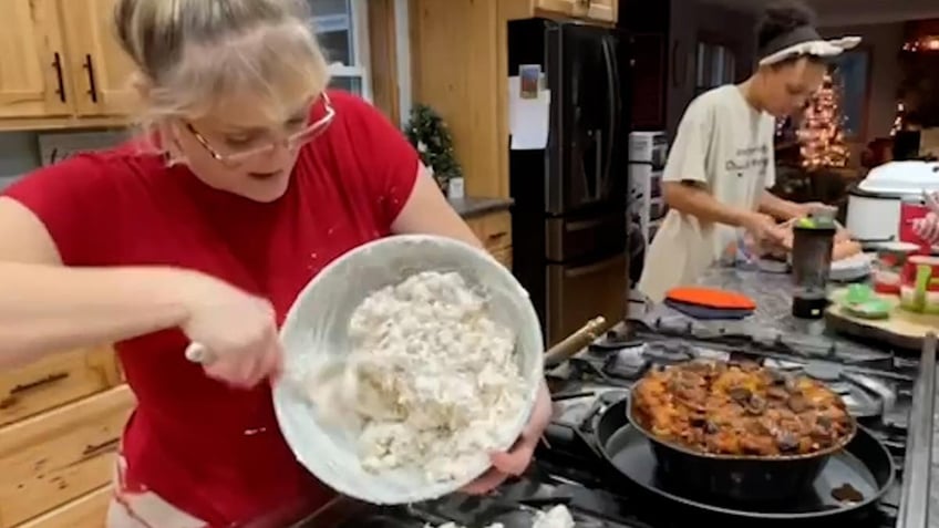 Mom cooking with daughter in the background