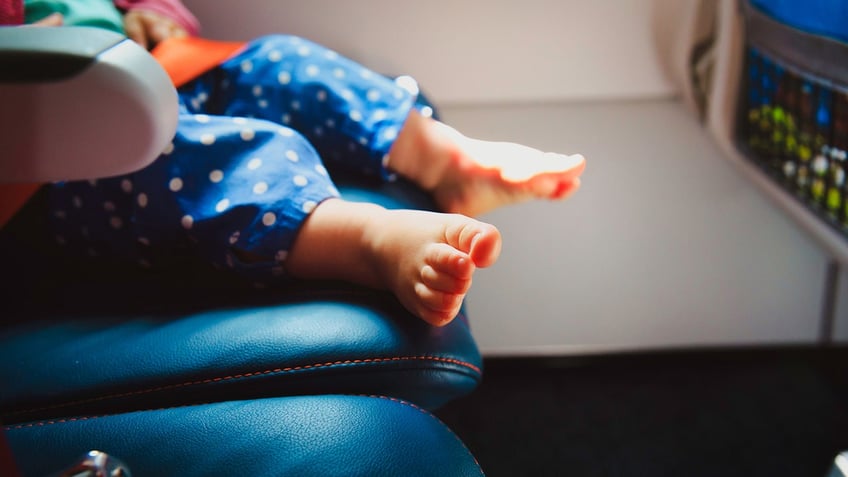 Baby feet on airplane seat