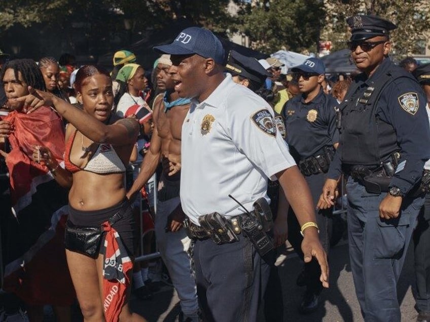 Police move revelers from the street after a shooting on Eastern Parkway, near the corner