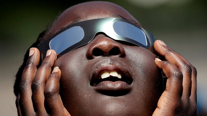 Someone with glasses watching a solar eclipse