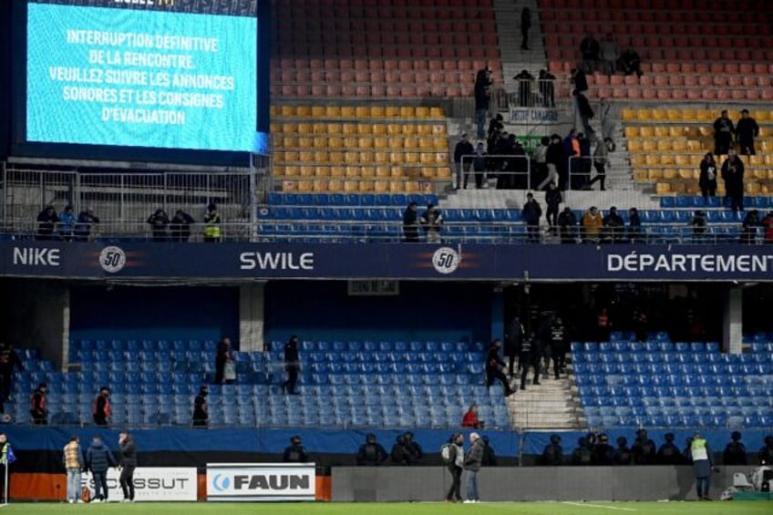 Riot police officers evacuate the stands after Sunday's Ligue 1 clash between Montpellier