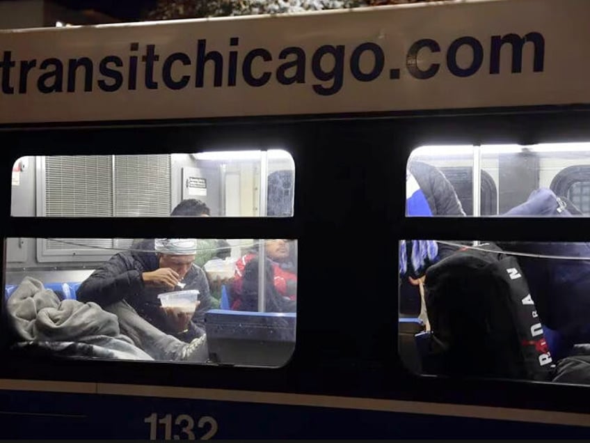 Outside the 1st District police station, migrants eat and take a break from the cold weather on a Chicago Transit Authority warming bus on Oct. 30, 2023. (Terrence Antonio James/Chicago Tribune/Tribune News Service via Getty Images)