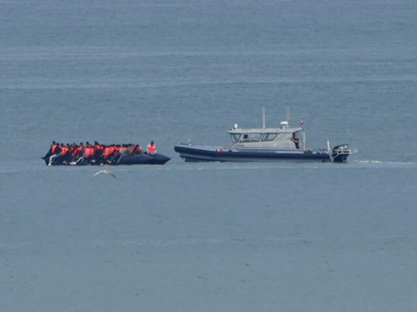 A boat thought to be with migrants is escorted by a vessel from the French Gendarmerie Nat