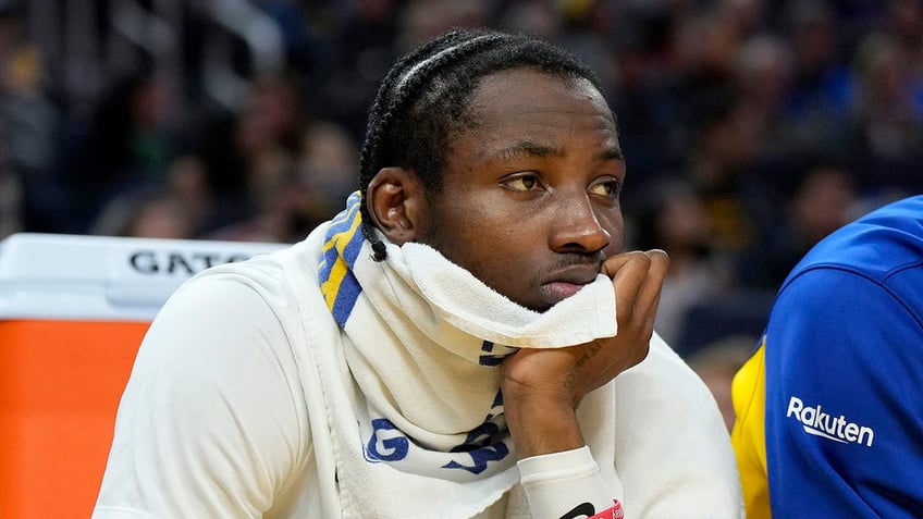 Jonathan Kuminga watches a game from the bench