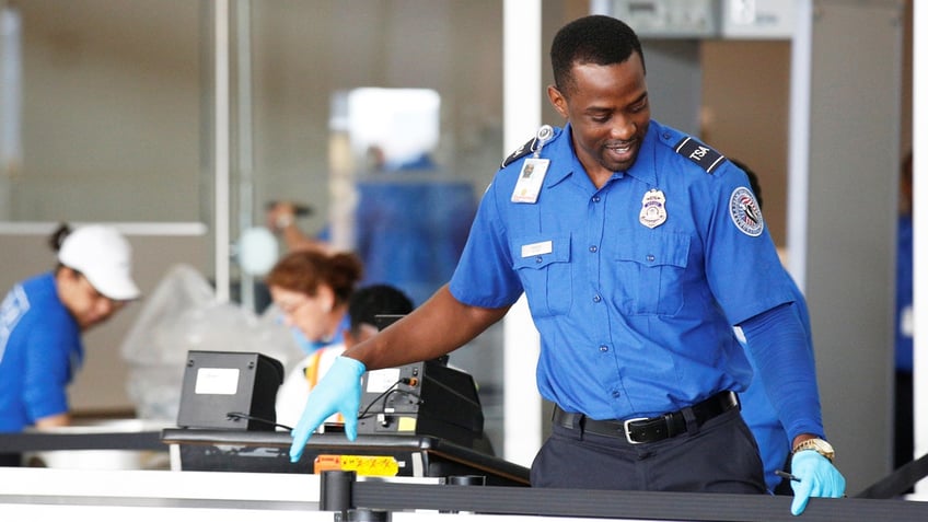 A Transportation Security Administration (TSA) agent works at an airport