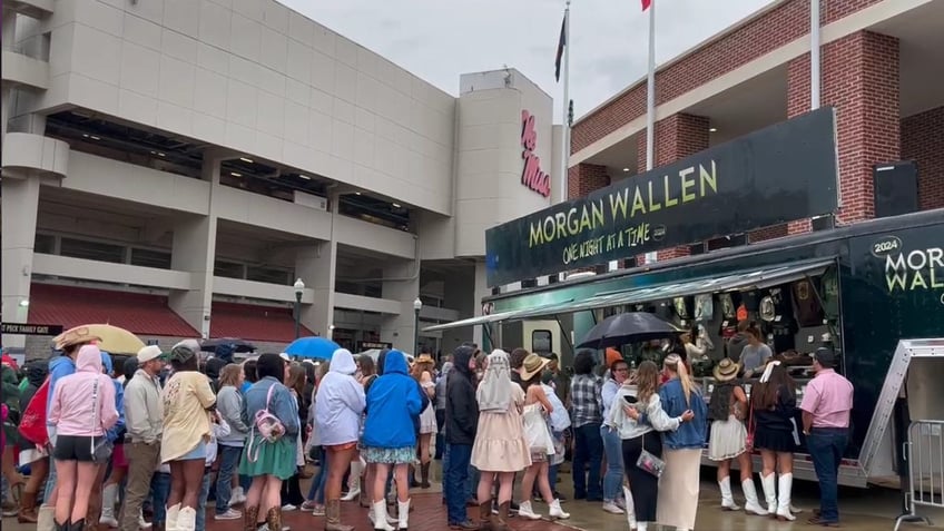 fans line up in the rain to enter the stadiun at the morgan wallen concert
