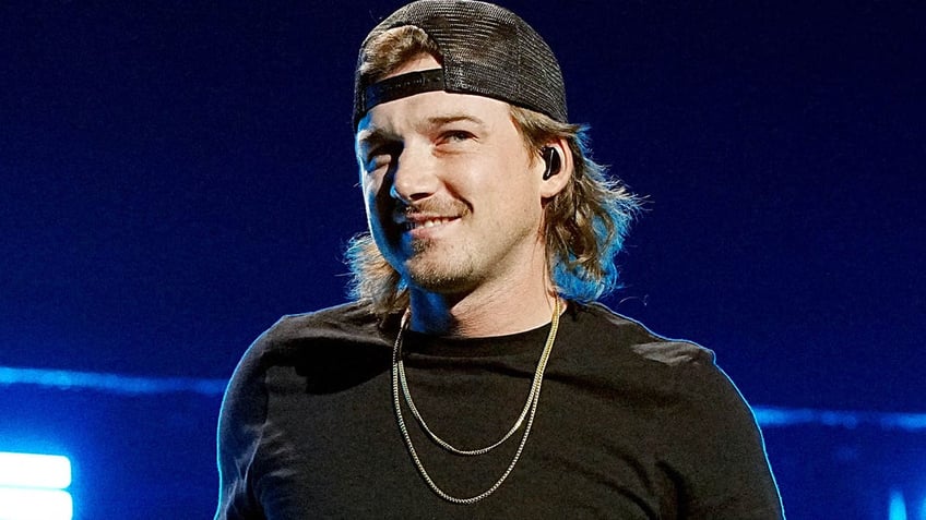 morgan wallen slightly smiling looking to the side on stage