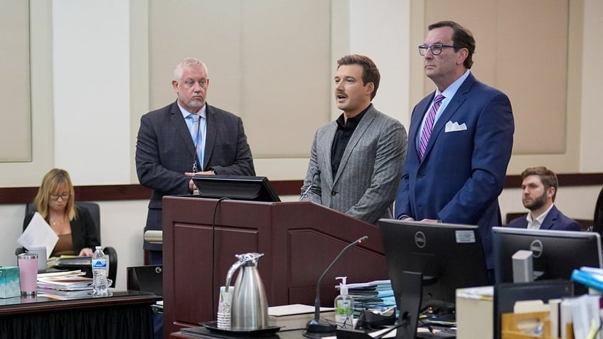 Morgan Wallen stands with his attorneys at a court hearing