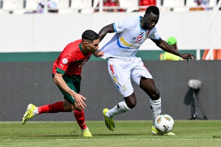 Achraf Hakimi (L) of Morocco and Silas of DR Congo, the goal scorers, battle for the ball.