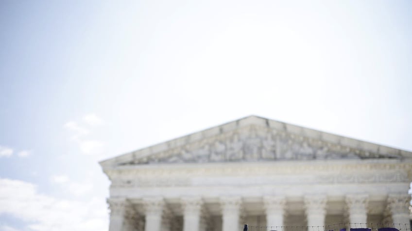 Supreme Court with "power" sign in front of it